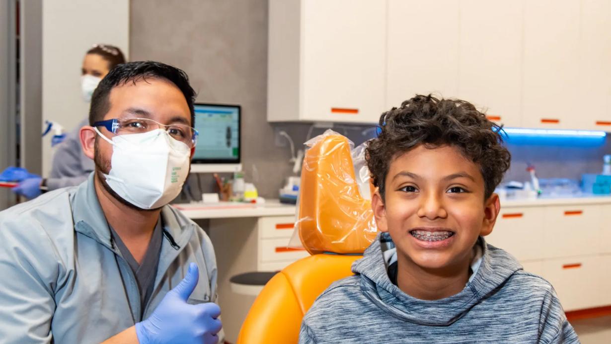 Orthodontist and young boy smiling