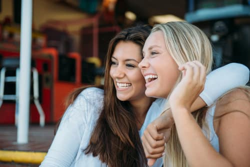 Two girls smiling and hugging