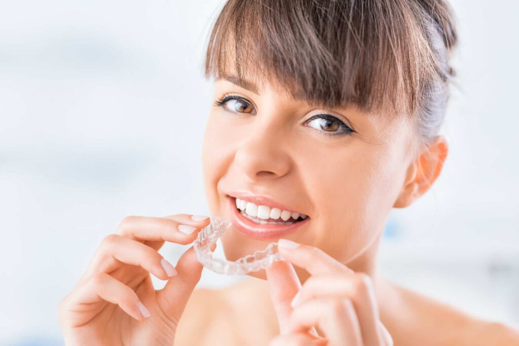 A woman about to put in an aligner